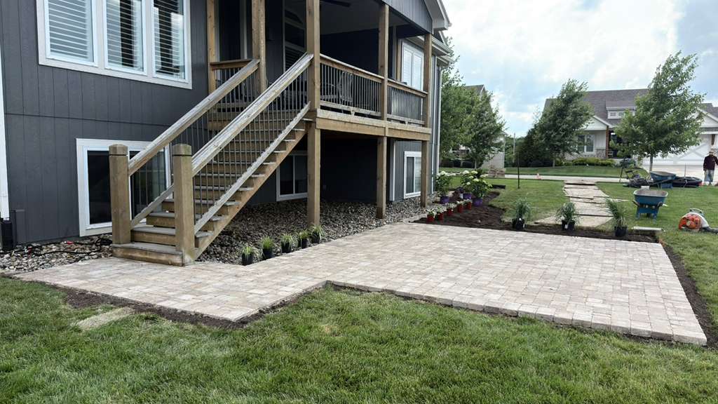 New paver patio under a deck with fresh plantings