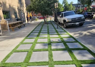 Turf and concrete paver grid walkway along a city sidewalk