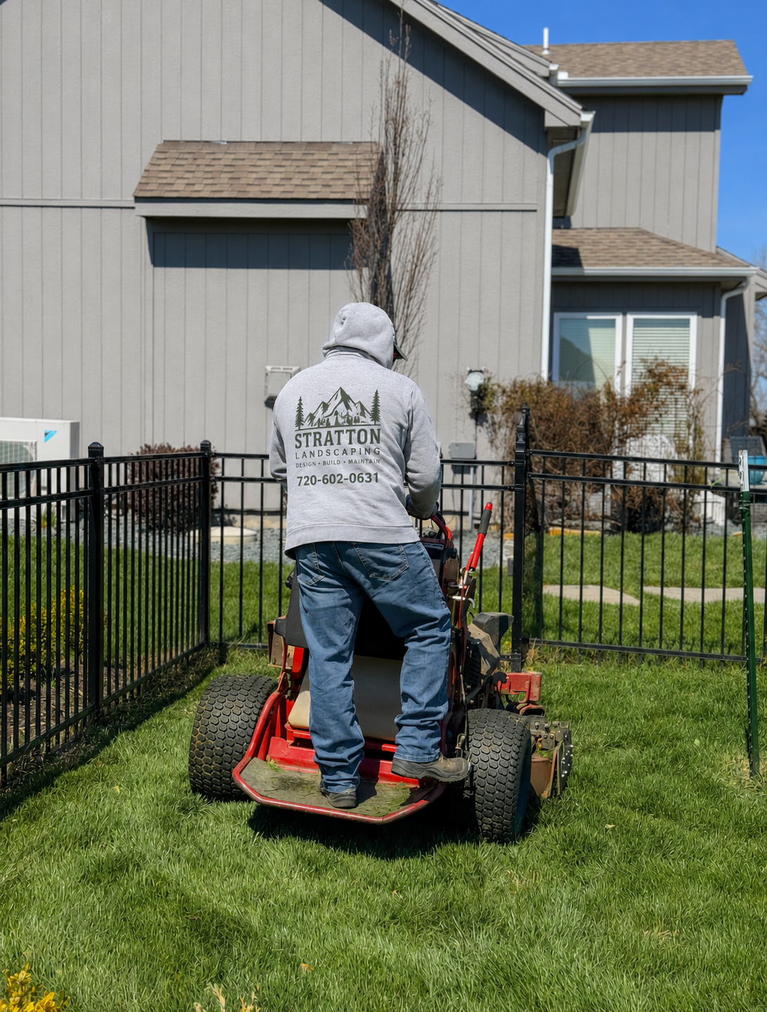 Stratton Landscaping crew member mowing a Denver-area lawn